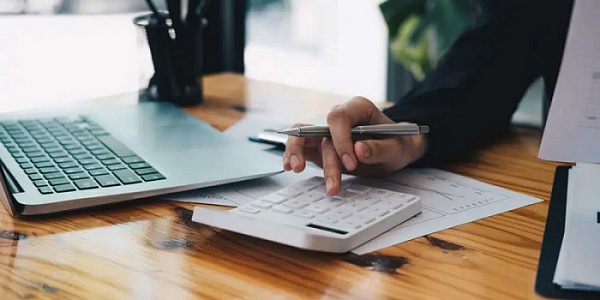 Pessoa Digitando em Uma Calculadora Sobre a Mesa